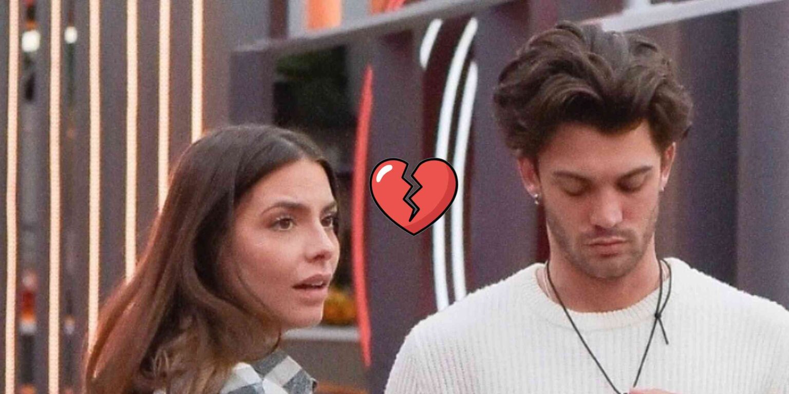 Due concorrenti in salone al GF con sguardi tesi e foglio in mano